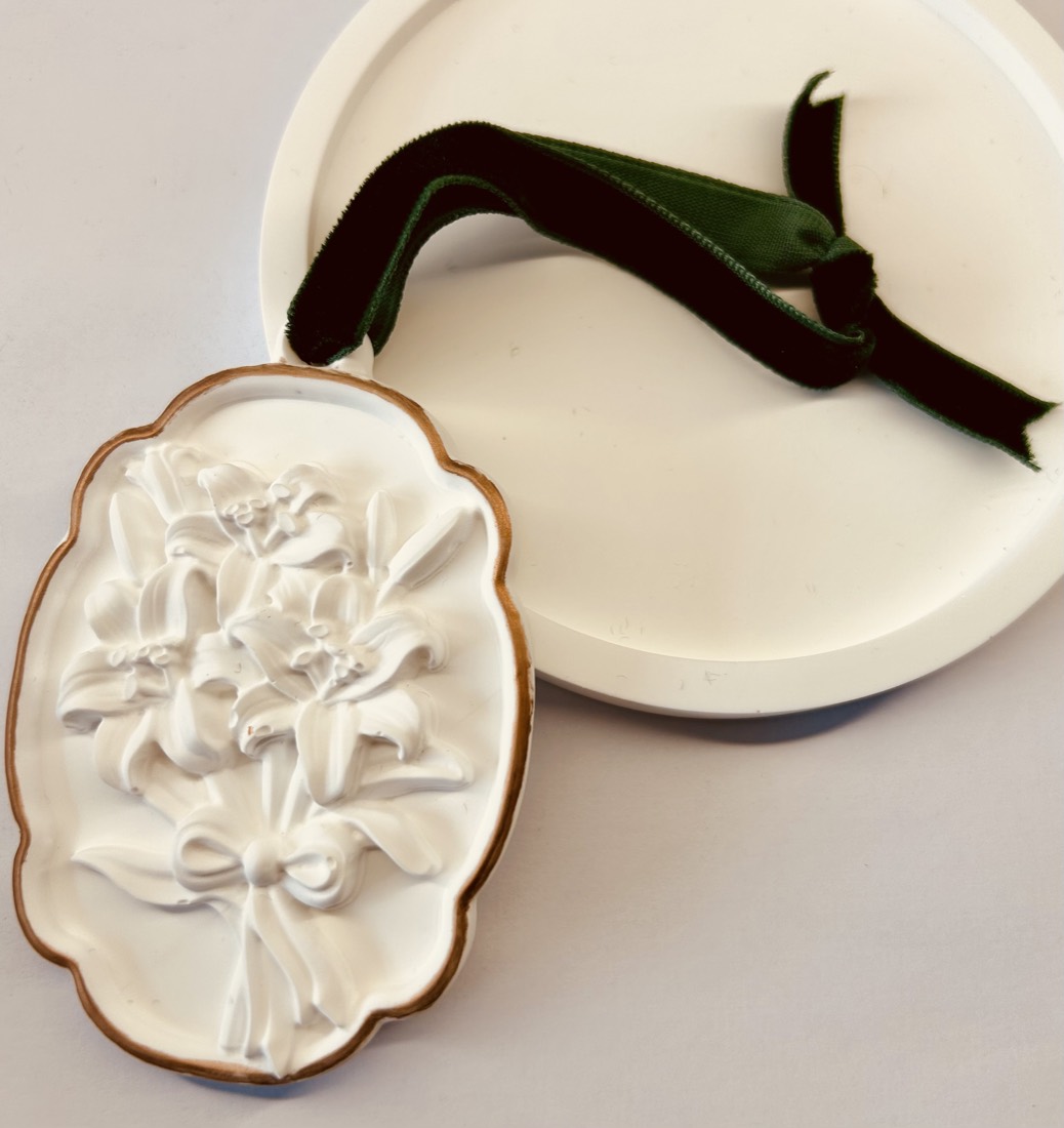 The Cloakroom gypsum diffuser, a plaster tiger-lily relief with green velvet ribbon